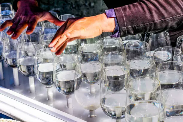 Photo of street artist plays full glasses of water and creates melodies in Berlin in Germany