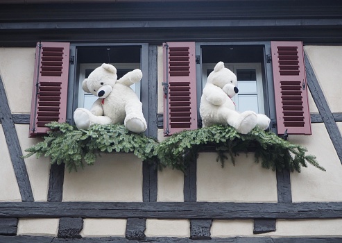 Christmas decorations and teddy bears in the window of an unrecognisable building. Features altered to de identify structure