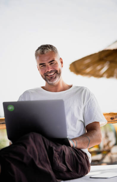 istock Man with his laptop working on the beach 1176019513