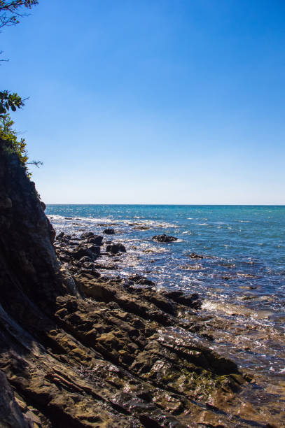 istock rocky sea shore with pebble beach, waves with foam 1176024738