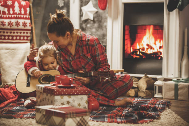 matriz e filha que jogam a guitarra junto em uma véspera de natal - party tea party tea child - fotografias e filmes do acervo