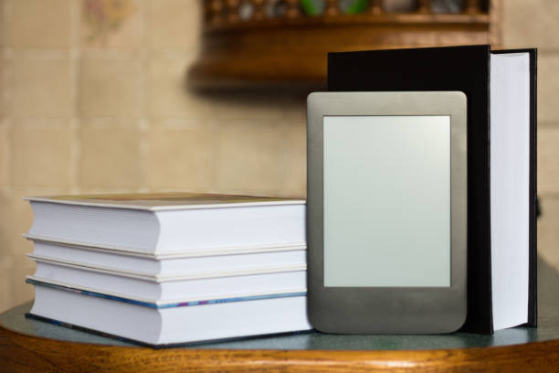 istock Modern e-book on the background of a stack of thick paper books. Close-up with selective focus. Training and technology concept 1176032392