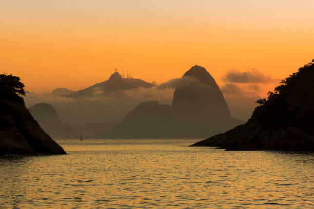 segelboot in guanabara bay mit zuckerhut berg und christus die erlöser statue im hintergrund. blick vom strand piratininga in niteroi. - sugarloaf mountain mountain rio de janeiro brazil stock-fotos und bilder