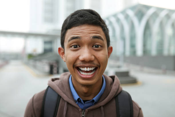 retrato de un joven guapo sonriente - raised eyebrows women human face thinking fotografías e imágenes de stock