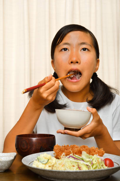 istock Japanese girl enjoys having dinner 1176047056
