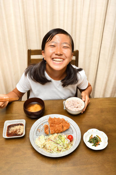 istock Japanese girl enjoys having dinner 1176047063