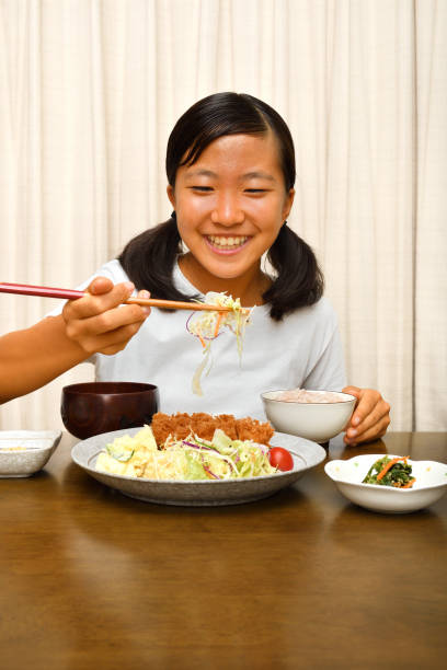 istock Japanese girl enjoys having dinner 1176047066