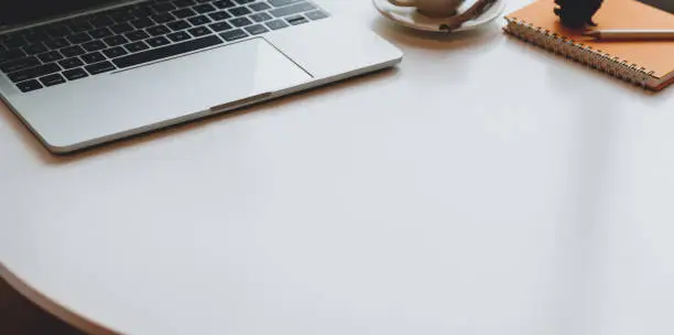 Photo of Modern workplace with laptop computer and office supplies on white table