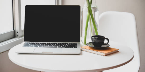 istock Minimal workplace with open laptop, coffee cup and office supplies 1176048564