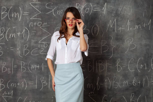 young smart woman with glasses near blackboard with maths formulas
