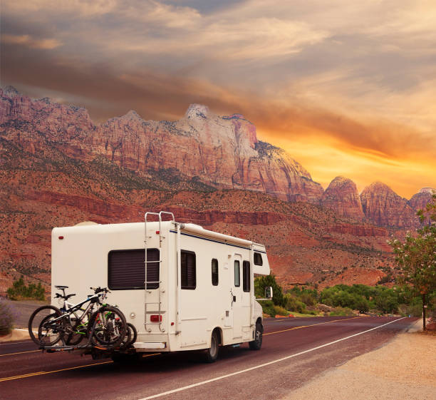 Mobile home with bicycles on Road trip Highway road with motor home at sunset motor home photos stock pictures, royalty-free photos & images