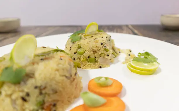 Photo of Close up selective Focus of South Indian breakfast Upma on plate with Vegetables