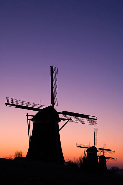 istock colorful sunrise behind three traditional Dutch windmills in a row 117605668