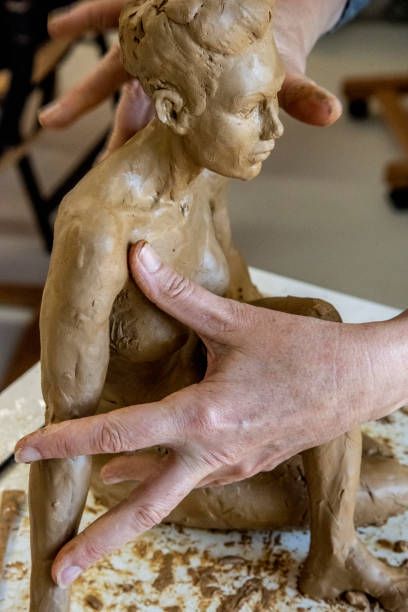istock Mature woman sculptor works on her clay models in her studio. 1176066685