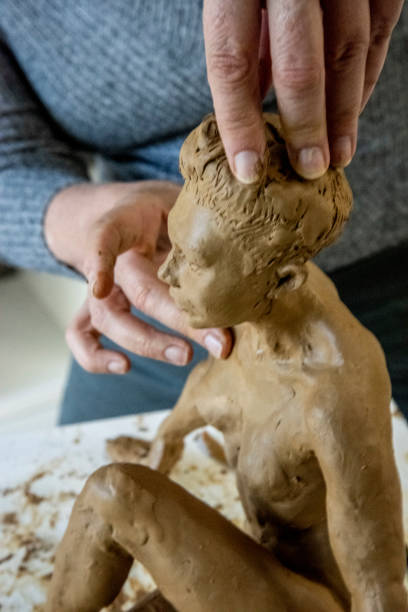 istock Mature woman sculptor works on her clay models in her studio. 1176067294