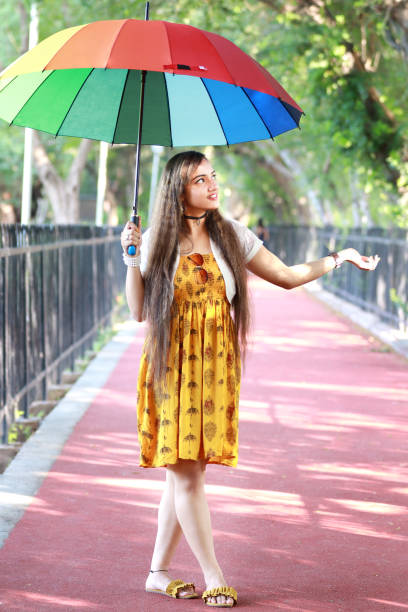 istock Young girl holding sunlight umbrella, checking sunlight 1176074601