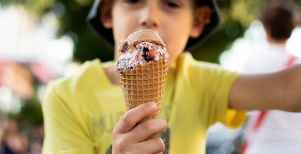 istock A kid is holding an ice-cream with nice blurred background. 1176074785