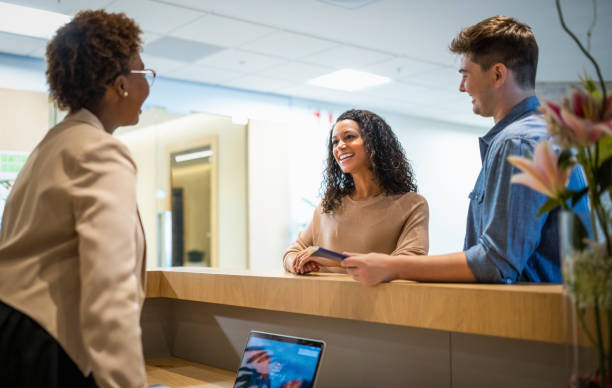 istock Smiling woman talking with receptionist at desk 1176079024