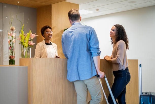 istock Smiling receptionist and couple standing at desk 1176079074