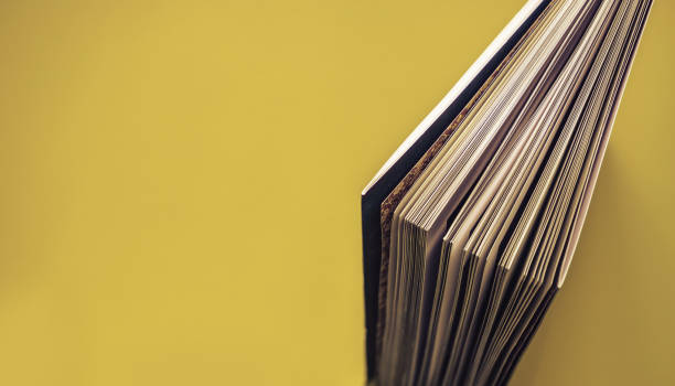 Close up beautiful book top view on a yellow background table.