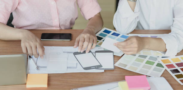 istock Cropped shot of professional UI web developers discussing on the smartphone templets 1176080118