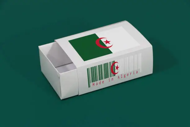 Photo of Algeria flag on white box with barcode and the color of nation flag on green background, paper packaging for put match or products.