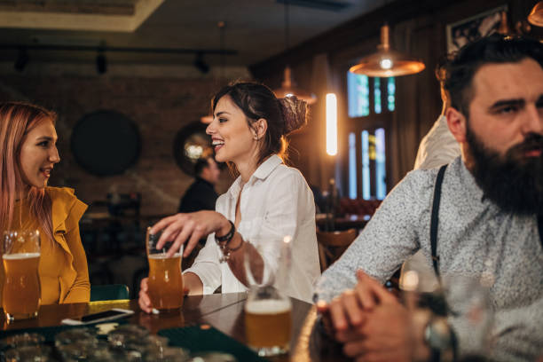 istock Group of young joyful friends having fun in a pub 1176089487