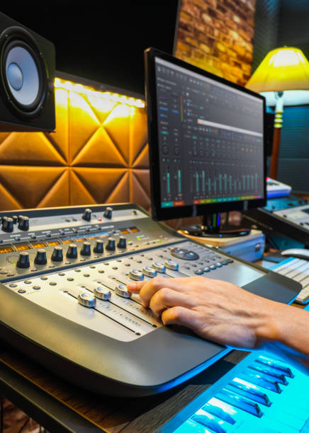istock sound engineer hand adjusting volume level on audio mixing console in recording, broadcasting studio 1176089788