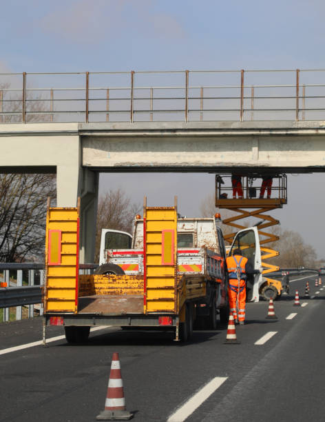 istock mean at work to maintenance a bridge over highway 1176090849