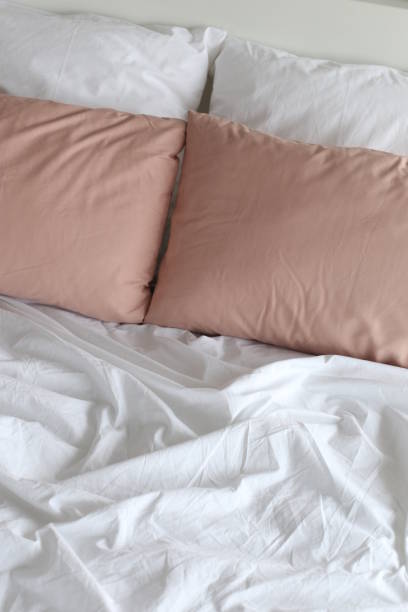 istock bed bedroom pillows white beige textile texture 1176092181