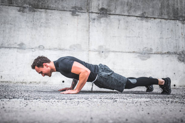 istock Side View of Determined Young Male Athlete Doing Push-Ups 1176094105