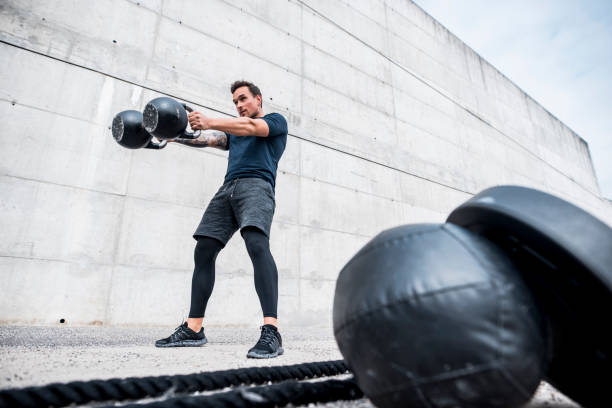 istock Athlete Holding Two Kettlebells with Fully Extended Arms 1176094114