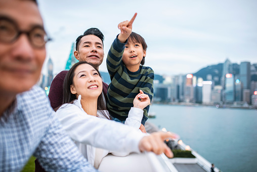 Chinese boy enjoying Hong Kong views with parents and grandfather from Harbour City’s Ocean Terminal Deck. ++ NB: Attached PR for Harbour City covers Ocean Terminal Deck which is on the roof of the shopping centre. Mention of both in metadata has been approved.