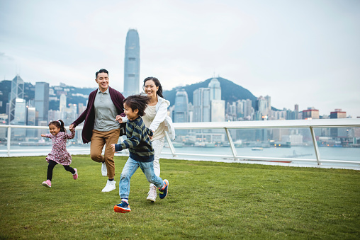 Young Chinese Children Leading Parents Across View Deck