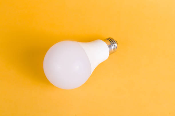 istock Single Energy saving home led light bulb with yellow background 1176099714