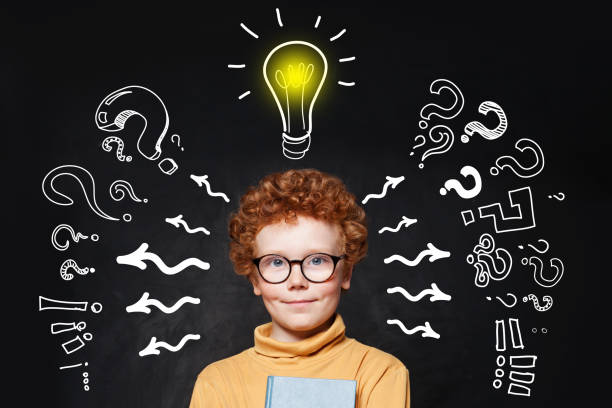istock Portrait of young boy with question marks and lightbulb 1176102849