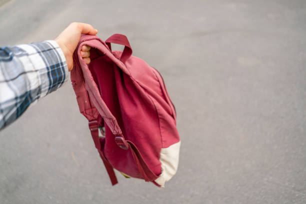 istock hand with  red backpack on a hiking vacation, moving to journey 1176105256