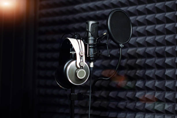 istock Microphone close - up on the background of a professional recording Studio. Workplace singers and musicians. Microphone stand and headphones for recording vocals, speakers and sound of musical instruments. 1176105406