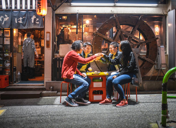 istock Young Friends Enjoying Drinks Outdoors at Tokyo Izakaya 1176105570