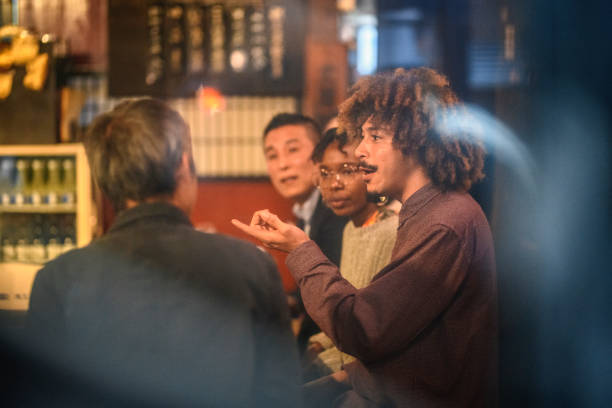 Multi-Ethnic Group Sitting at Sushi Bar in Tokyo Izakaya