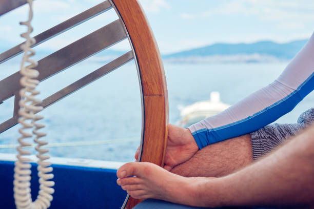 istock Sailor using wheel to steer rudder on a sailing boat. 1176106618