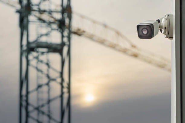 CCTV or surveillance camera on blurred construction crane dusk sky background stock photo