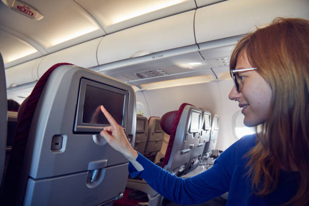 istock Woman using touchscreen in modern airplane seat. 1176107600
