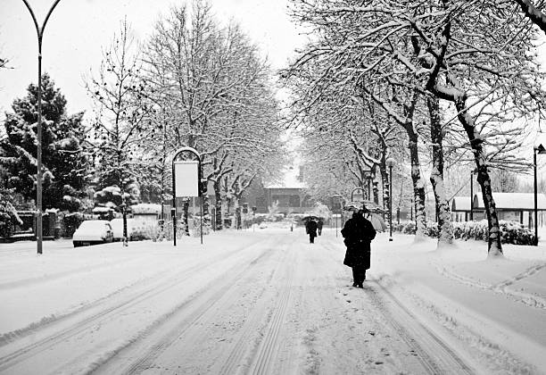 снежная улица с человек ходить. черный и белый - thick snow стоковые фото и изображения