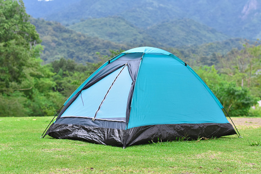 Light blue color dome tent and mountain range landscapes in the background.