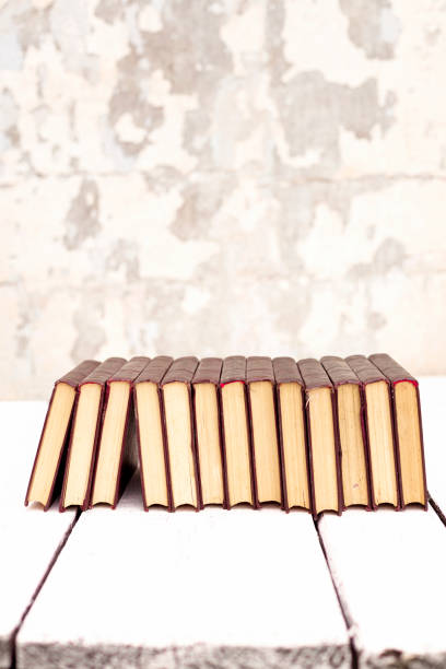 istock Stack of old ancient shabby books on a white wooden background. 1176111974