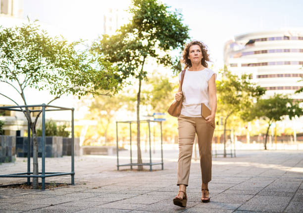 istock Businesswoman walking while looking away in city 1176113251