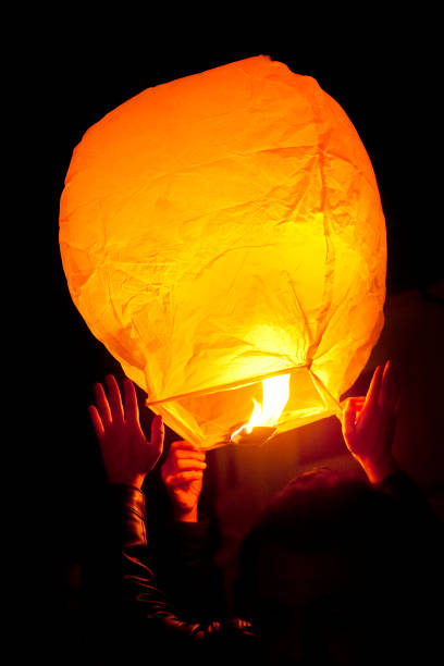 istock Floating Lantern Festival, flying balloon takeoff, hands holding. 1176114249