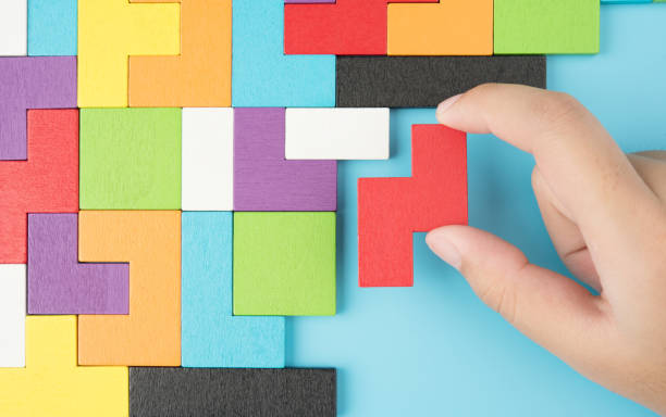 Hand push last piece jigsawto finish success planning concept solve puzzle isolated on blue background top view , logical thinking