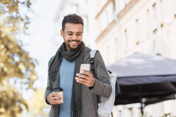 Handsome young man using smart phone in a city